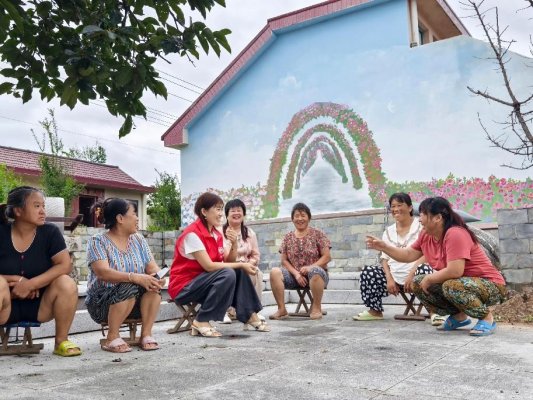 2“初心红”巾帼志愿服务队代表向群众讲解政策